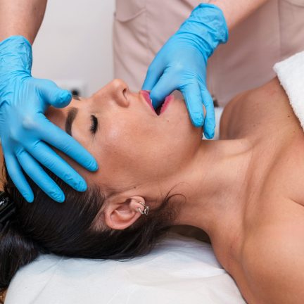 Patient receiving TMJ stretching treatment for jaw discomfort relief.